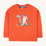 Frugi Owen Top - Bonfire/Lemur. A bold orange top with a funny lemur riding a scooter