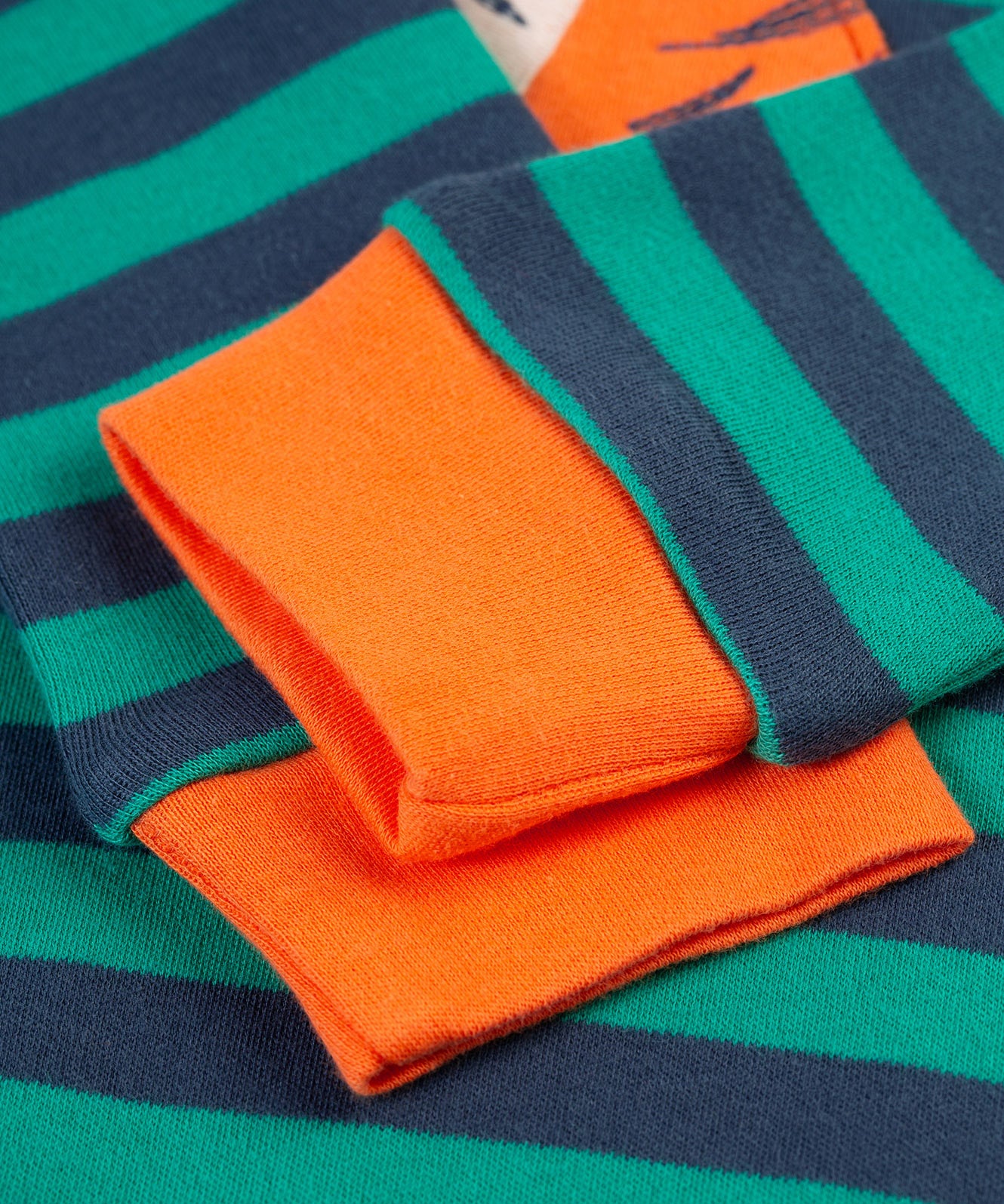 A look at the orange wrist cuffs on the Frugi Rowan Romper - Iguana Stripe/Tiger