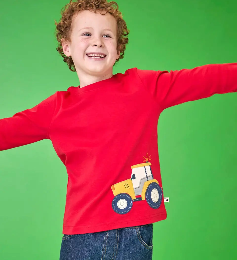 Frugi organic cotton Scout top in red with yellow tractor applique near hem, worn by boy.