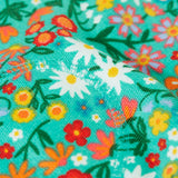 Frugi GOTS 100% organic cotton snuggle joggers in light green with a floral design showing close up of padded kneepatch