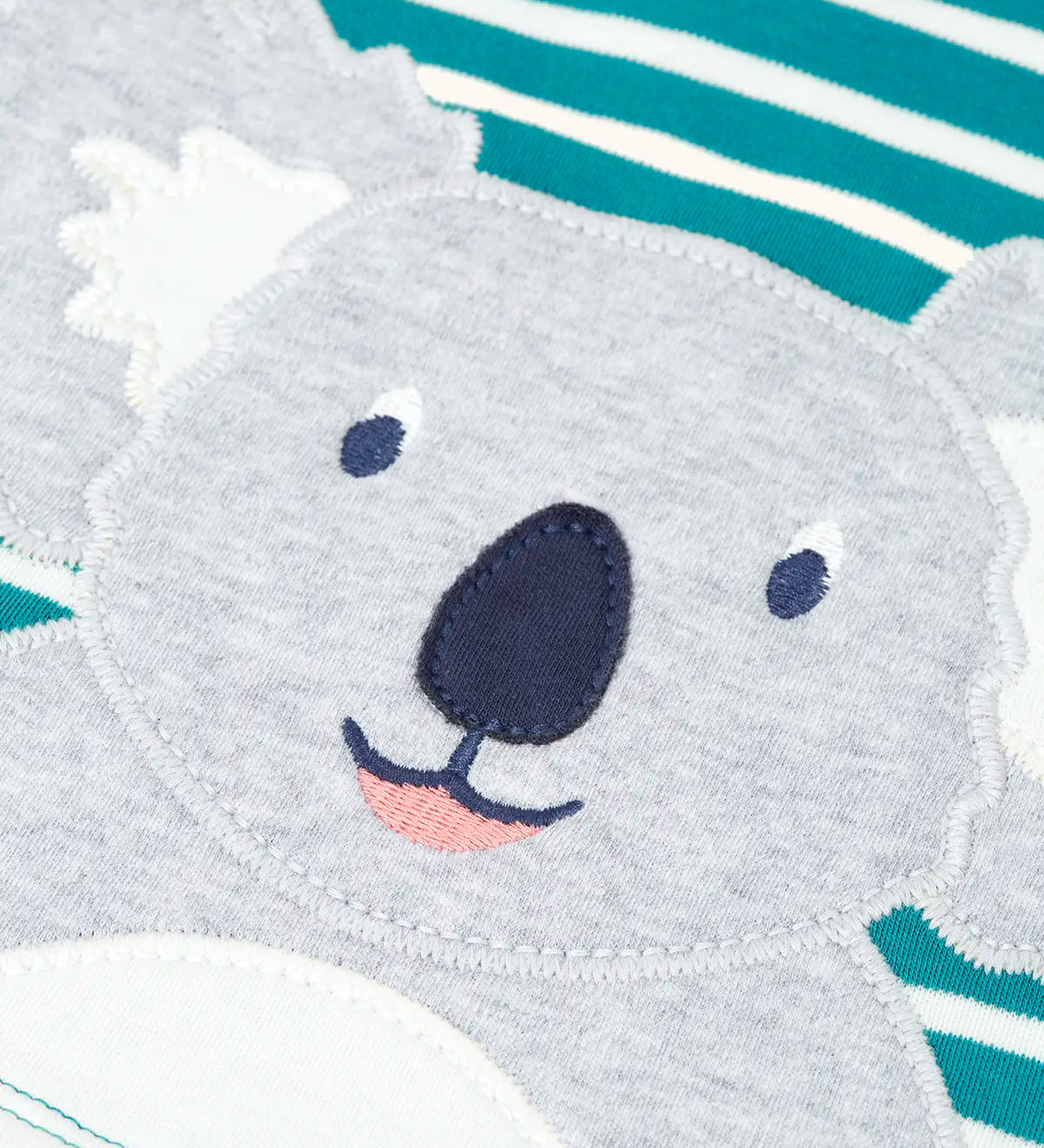 Frugi kids long sleeve top showing a close up of the playful koala applique on blue and white striped organic cotton fabric