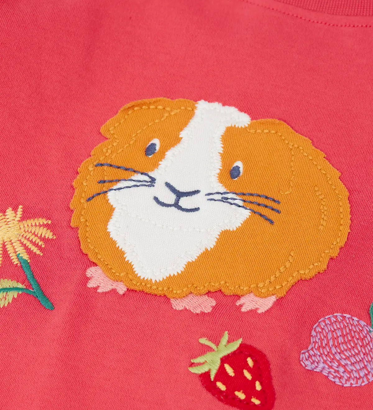 Frugi kids long sleeve top showing a close up of the playful guinea pig applique on pink organic cotton fabric