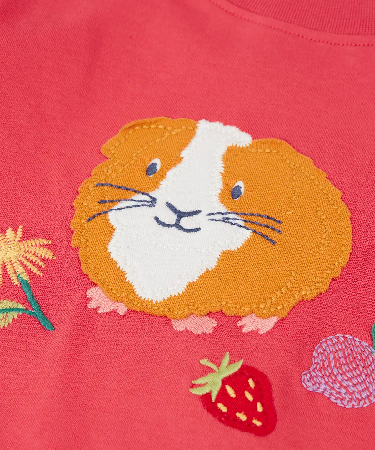 Frugi kids long sleeve top showing a close up of the playful guinea pig applique on pink organic cotton fabric
