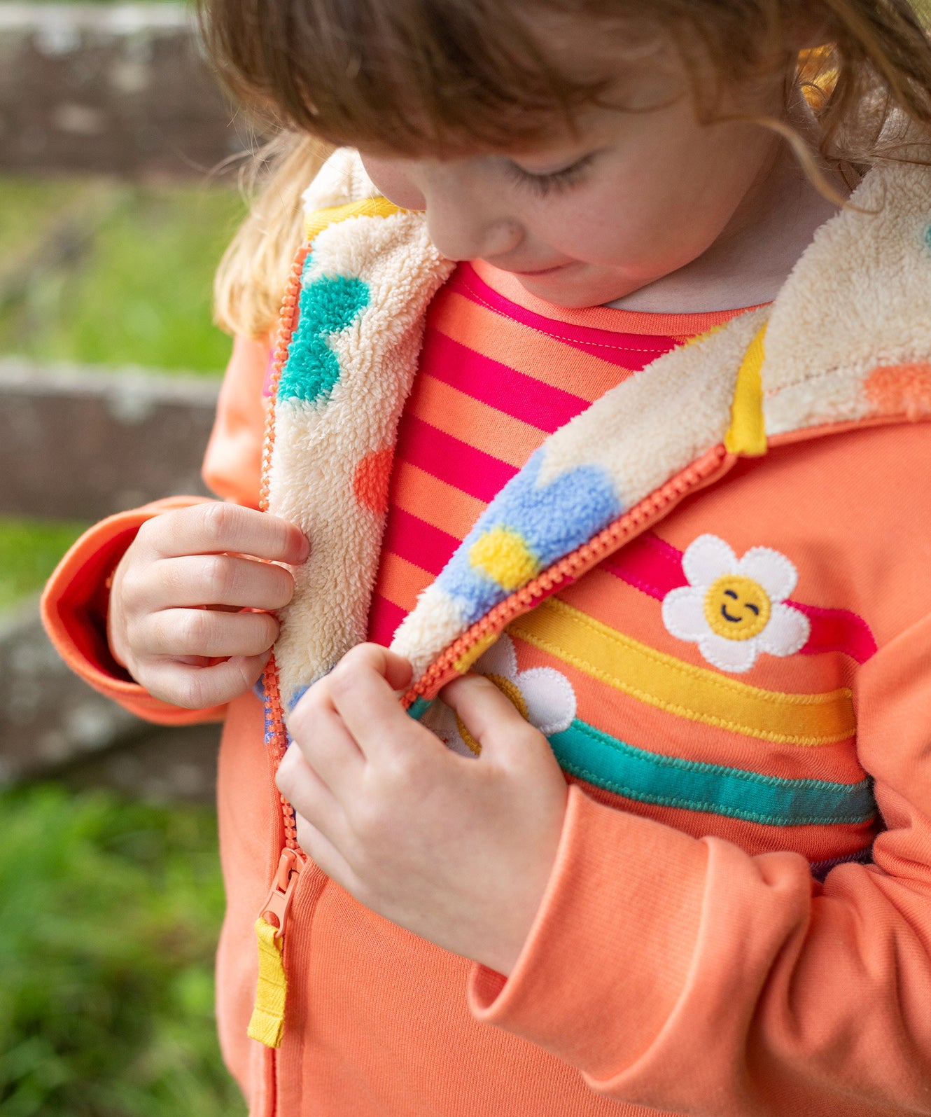 A child looking down at the flower pop fleece inside the jacket