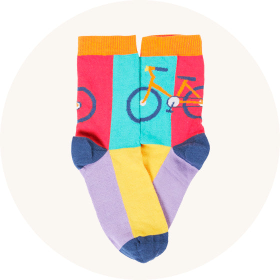 Frugi Rock My Socks Trails in colour block purple and yellow soles, blue and red angle with bike, made from organic cotton, to represent kids socks at Babipur.