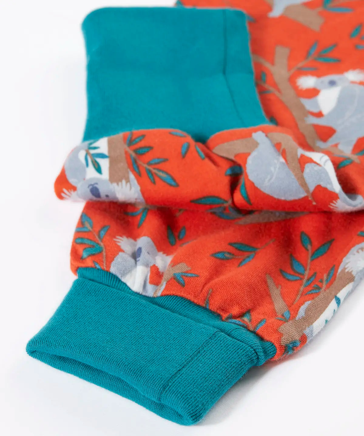 Frugi kids parsnip dungarees in salamander orange with repeating koala prints showing a close up of the fold up cuffs