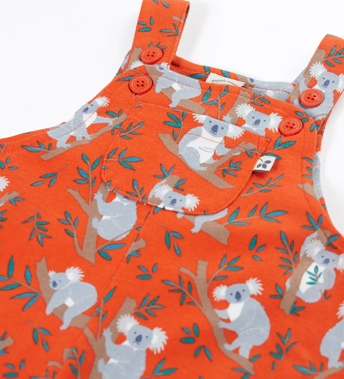 Frugi kids parsnip dungarees in salamander orange with repeating koala prints showing the adjustable shoulder straps and pocket pocket