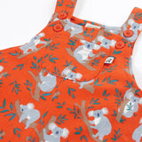 Frugi kids parsnip dungarees in salamander orange with repeating koala prints showing the adjustable shoulder straps and pocket pocket