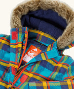 Frugi's Penhale parka coat in a blue red and yellow tartan check laid flat showing fur trim on the hood and navy fleece inner liner