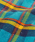Frugi's Penhale parka coat in a blue red and yellow tartan check showing a close up of the water beading 