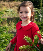 A close up of a child wearing Frugi Peony Corduroy Dress Red Robin showing the frilled collar detail. This is a Christmas party dress made from GOTS organic cotton - available at Babipur.
