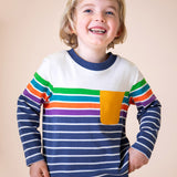 A child wearing the Frugi Piran pocket top in navy stripe available at Babipur. A GOTS organic cotton long sleeved top in a striped design. Features a yellow chest pocket