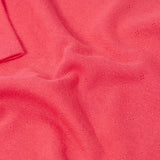 Frugi baby GOTS organic cotton pointelle body laid flat showing diamond stitch detail for breathability on pink organic cotton fabric 