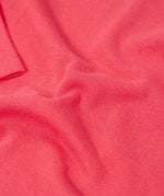 Frugi baby GOTS organic cotton pointelle body laid flat showing diamond stitch detail for breathability on pink organic cotton fabric 