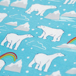 A close up of the Polar Bear, cloud, iceberg, and rainbow print on blue fabric, from the Frugi Easy Dressing Babygrow - Winter Tails