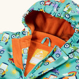 Frugi waterproof puddle buster coat in terrific tractors laid flat showing the front zip with velcro fastener and orange fleece liner with name tag
