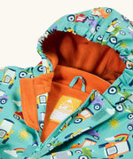 Frugi waterproof puddle buster coat in terrific tractors laid flat showing the front zip with velcro fastener and orange fleece liner with name tag