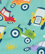 Frugi waterproof puddle buster coat in terrific tractors showing a close up of the repeating tractor design and water beading