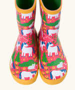 Front of Frugi puddle buster wellington boots showing the repeating cat and pony design on pink natural rubber material