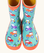 Front of Frugi puddle buster wellington boots showing the repeating tractor design on aqua natural rubber material