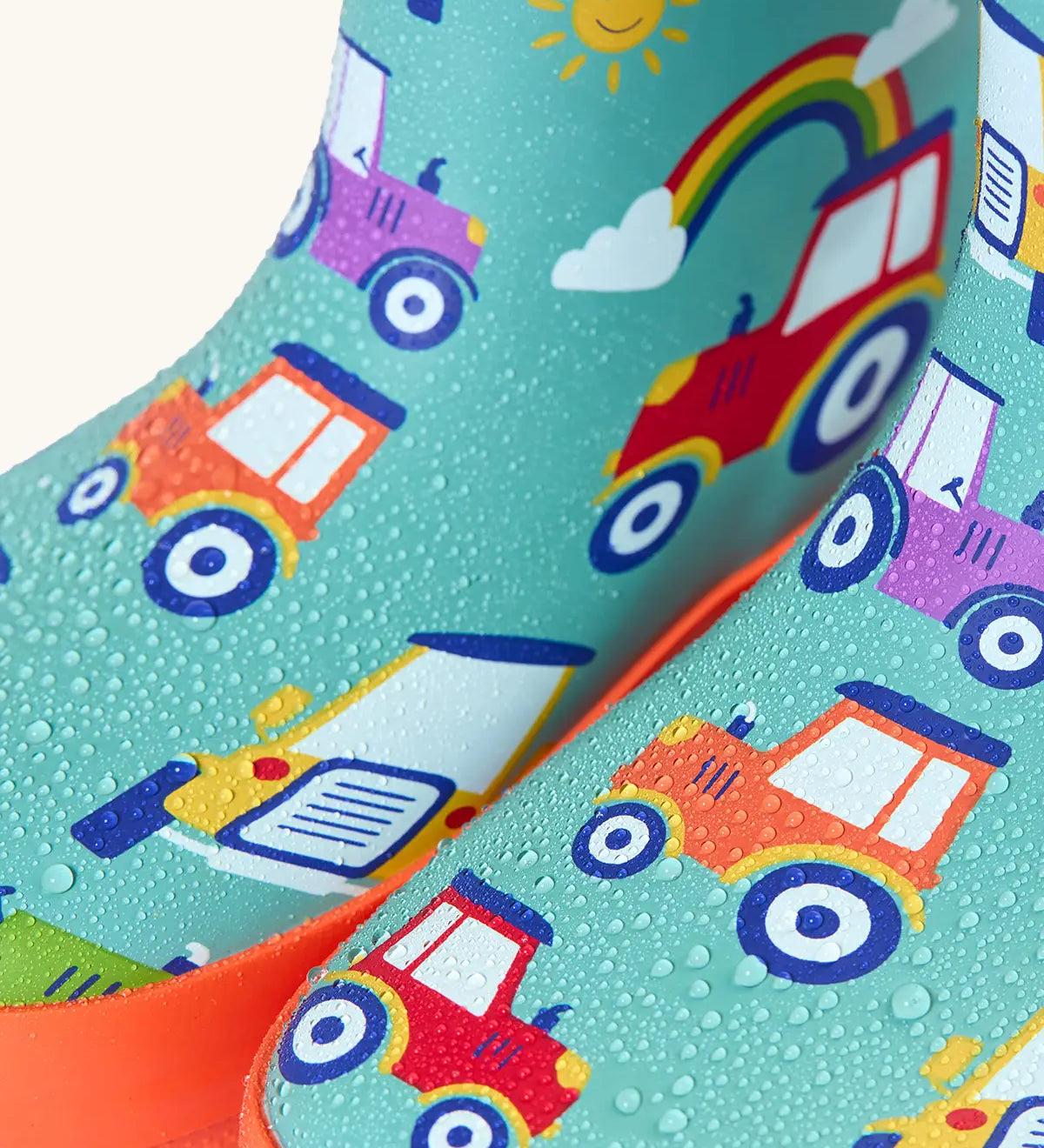 Frugi natural rubber, waterproof puddle buster wellingtons in terrific tractor design showing water beading 