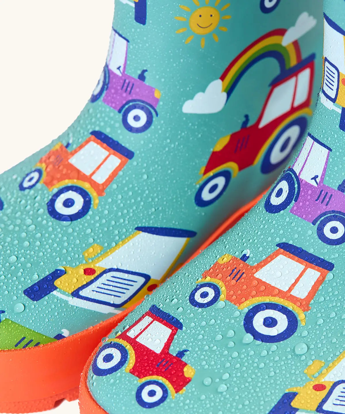 Frugi natural rubber, waterproof puddle buster wellingtons in terrific tractor design showing water beading 