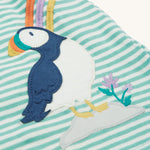 The Frugi Puffin applique on the Frugi Dolcie Dress - Moss Stripe/Puffin Rainbow