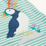 The Frugi Puffin applique on the Frugi Dolcie Dress - Moss Stripe/Puffin Rainbow