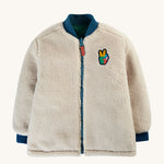 The fleece side of the Frugi Robin Reversible Quilted Jacket - Teal/Moon, with navy blue collar, zipper and wrist cuffs, and a Frugi peace patch on the chest