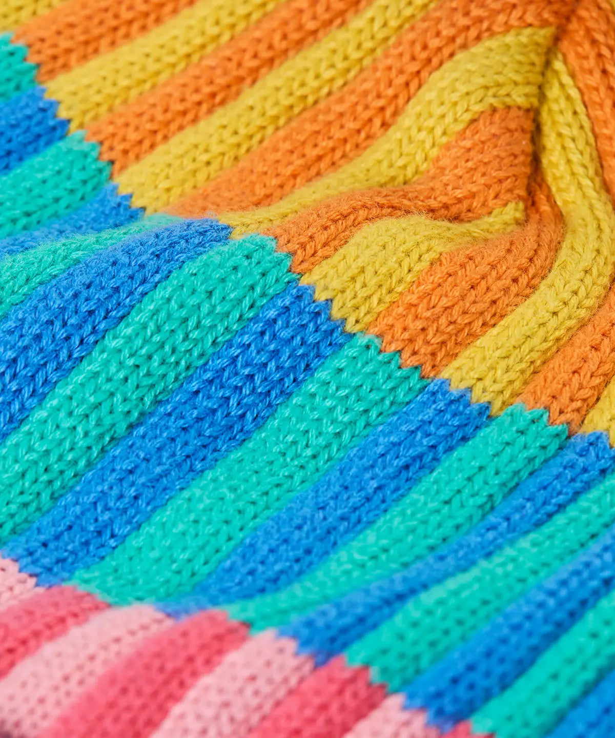 Frugi bobble hat showing close up of the rainbow stripe design on organic cotton fabric