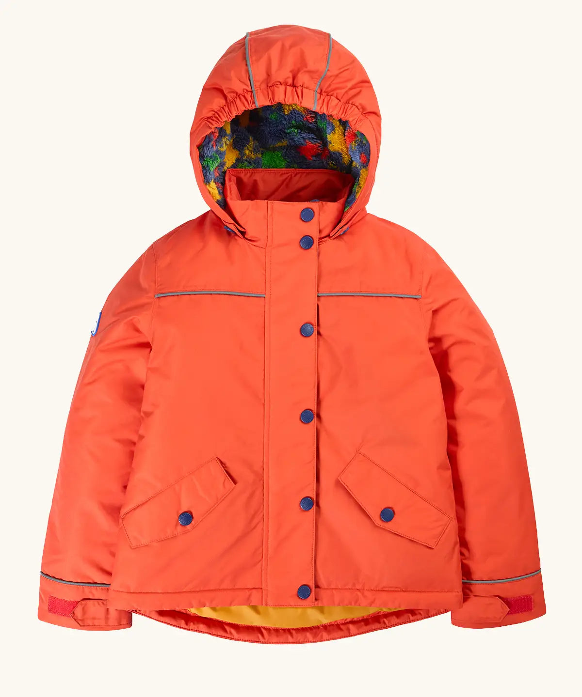 Frugi kids 3 in 1 rambler coat in fire upon a star. A orange waterproof coat Features a removable hood and 2 side pockets and a fleece inner