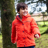 Child wearing the Frugi kids 3 in 1 rambler coat in fire orange in the outdoors with the front zip and popper fully fastened. Coat has a relaxed fit