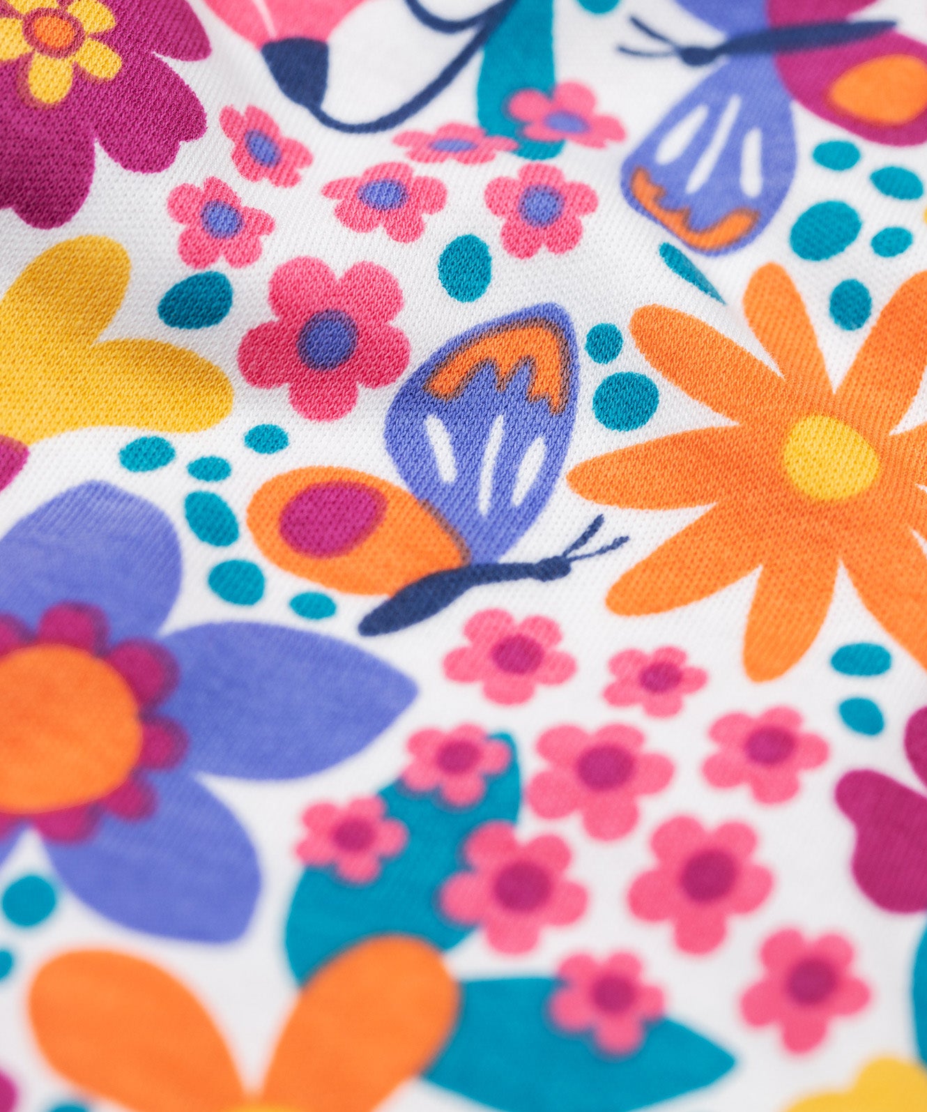 A close up of the retro floral design on the Frugi dragon skies Jamie jim jam bottoms available at Babipur. 