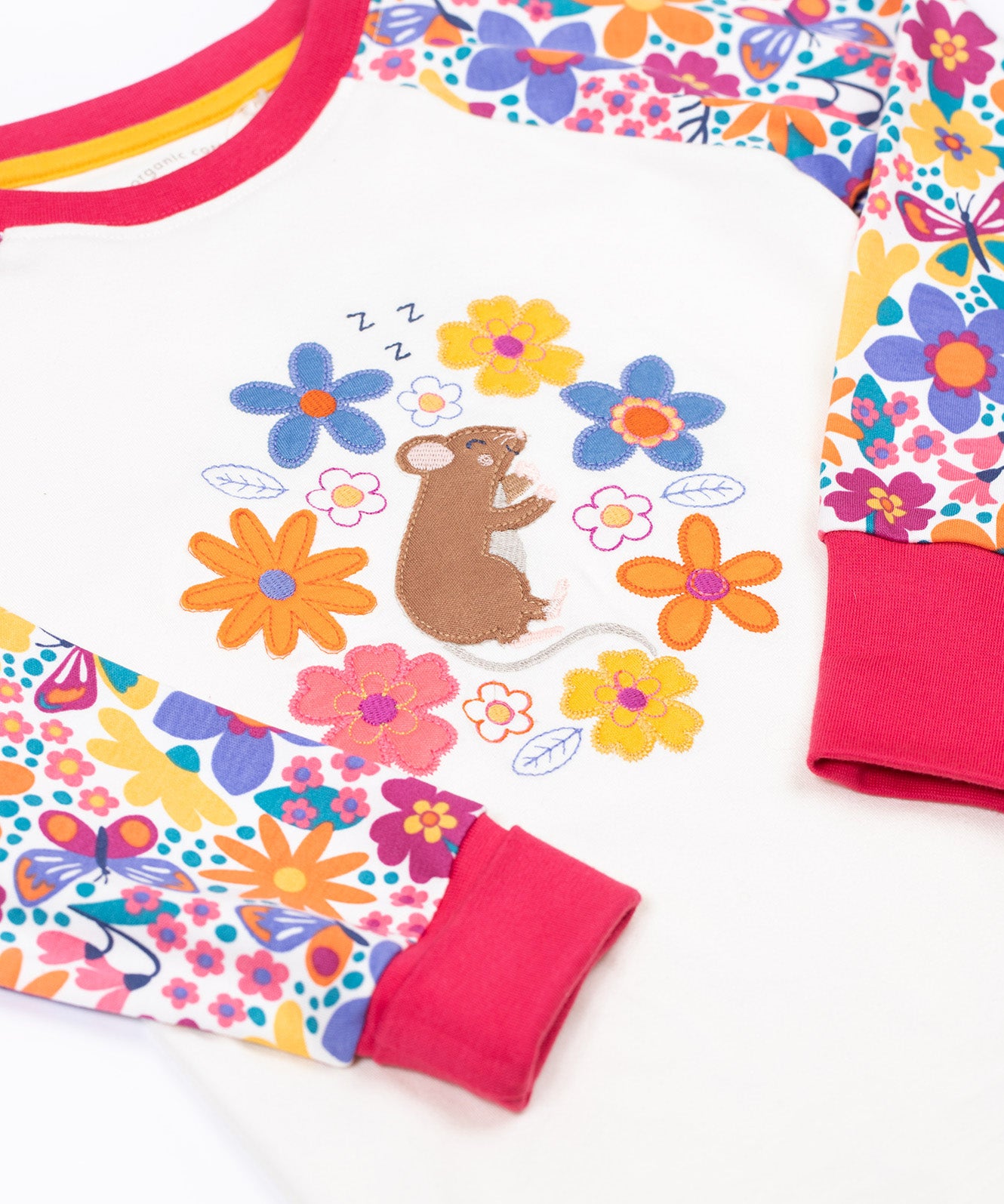 A close up of the cute brown mouse and flowers applique on the Frugi dragon skies Jamie jim jam top available at Babipur. 