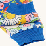 A closer look at the blue, ribbed elasticated ankle cuffs on the Frugi Snuggle Crawlers - Retro Happy. The image also shows the Retro Happy print on the trouser legs