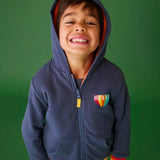 Frugi reversible navy zipped hoodie with elasticated rainbow cuffs with orange fleece lining, worn by boy.