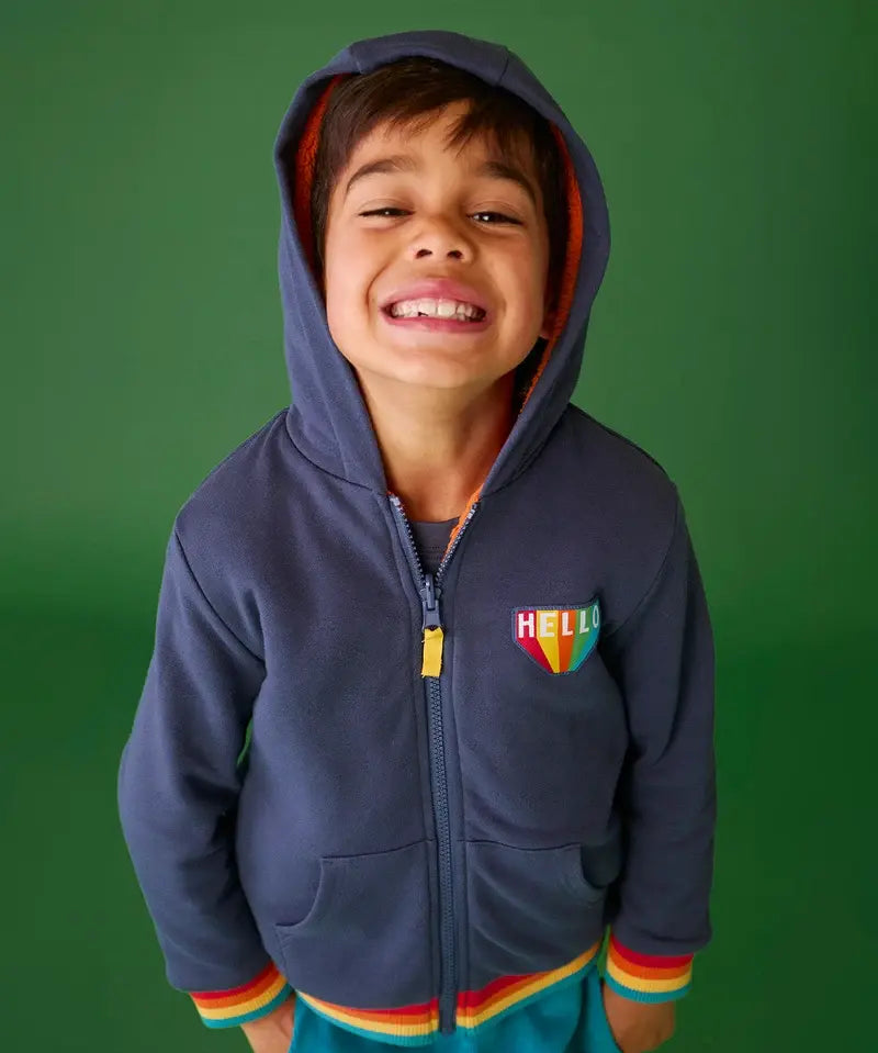 Frugi reversible navy zipped hoodie with elasticated rainbow cuffs with orange fleece lining, worn by boy.