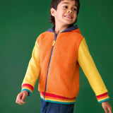 Frugi reversible hoodie in soft orange fleece, cotton yellow sleeves with rainbow elastic cuffs, worn by boy in jeans.