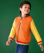 Frugi reversible hoodie in soft orange fleece, cotton yellow sleeves with rainbow elastic cuffs, worn by boy in jeans.