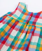 A close up of the rainbow check on the Frugi Rosalie Reversible Baby and Toddler Dress. One side features robin readbreast appliques on a Holly green cord with the other side featuring a rainbow coloured check. This dress is a part of a wide range of organic cotton clothing for children available here at Babipur. 