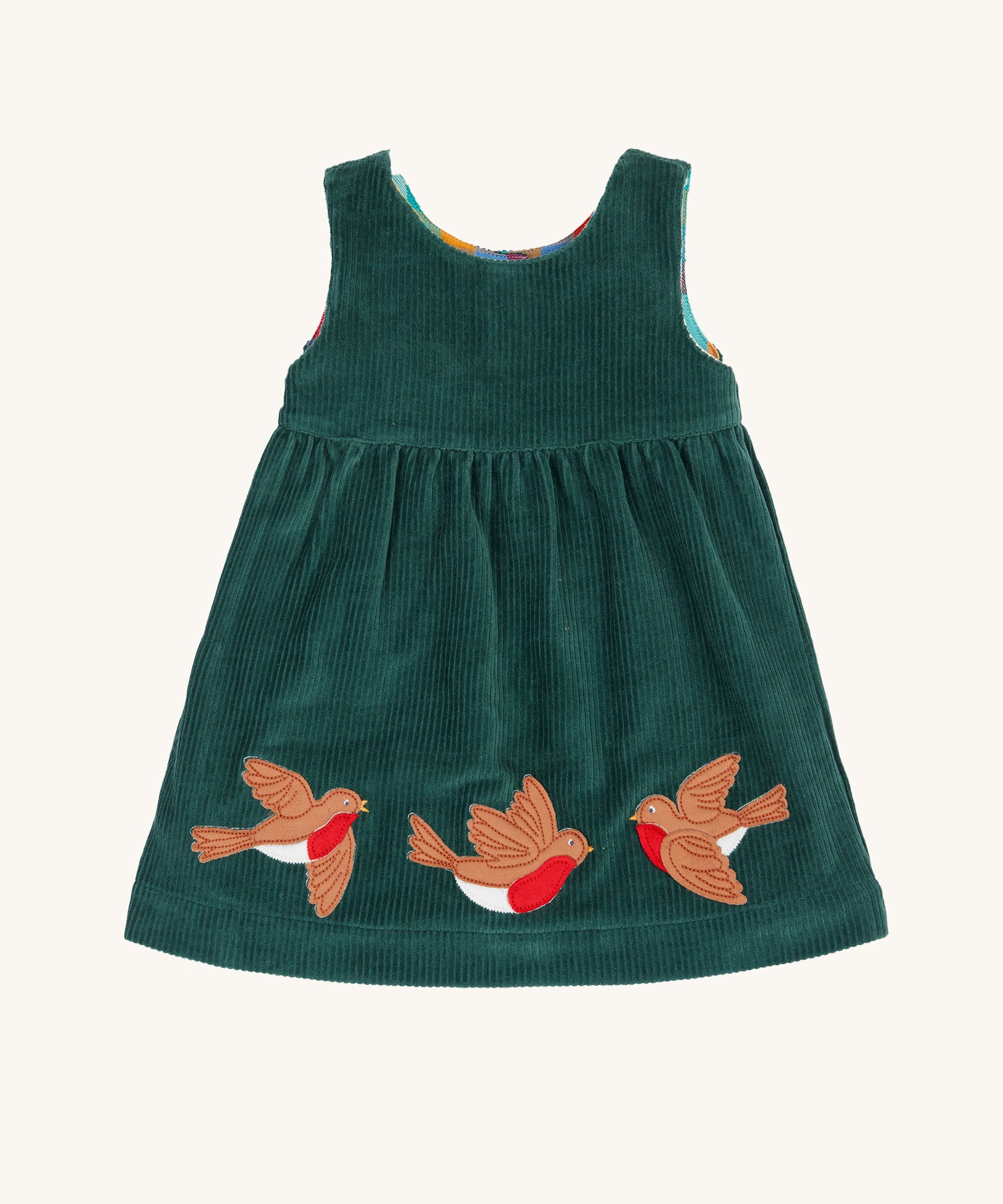 The holly green cord side of the Frugi Rosalie Reversible Baby and Toddler Dress. One side features robin readbreast appliques on a Holly green cord with the other side featuring a rainbow coloured check. This dress is a part of a wide range of organic cotton clothing for children available here at Babipur. 