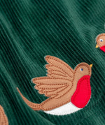 A close up of the robin appliques on the Frugi Rosalie Reversible Baby and Toddler Dress. One side features robin readbreast appliques on a Holly green cord with the other side featuring a rainbow coloured check. This dress is a part of a wide range of organic cotton clothing for children available here at Babipur. 