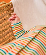 Frugi scrumptious baby with striped orange babygrow, made from organic cotton.