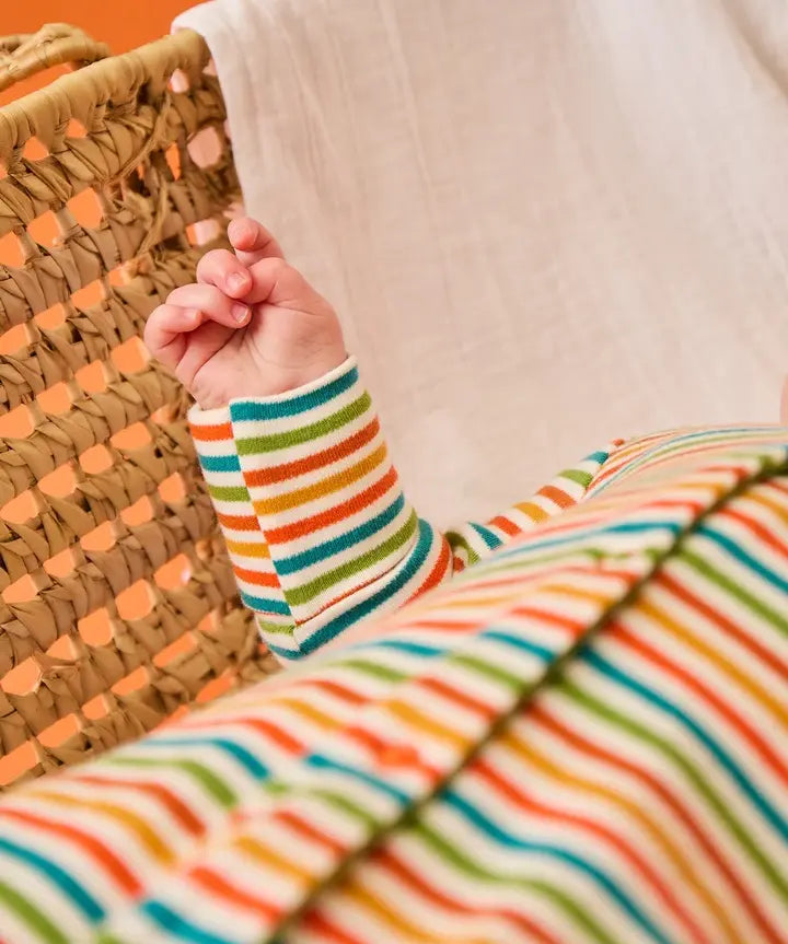 Frugi scrumptious baby with striped orange babygrow, made from organic cotton.