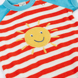 Frugi baby towelling romper laid flat showing blue sleeves, white and red stripe body, yellow sun on the front and popper fasteners
