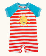 Frugi baby towelling romper with blue sleeves, white and red stripe body, yellow sun on the front and popper fasteners