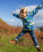 Child jumping in a field and wearing the Frugi recycled polyester snow and ski coat in starry slopes 