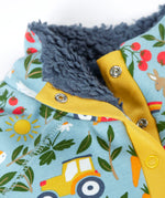 Close up of the light blue Frugi fleece showing the dark blue fleece inner and repeating farm themed print