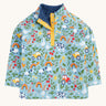 Frugi organic cotton fleece laid flat. In light blue with a repeating farm themes print. Features a dark blue fleece inner and popper fasteners 
