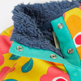 A close up of the yellow Frugi organic cotton fleece laid flat showing the navy fleece inner and 2 popper fasteners opened